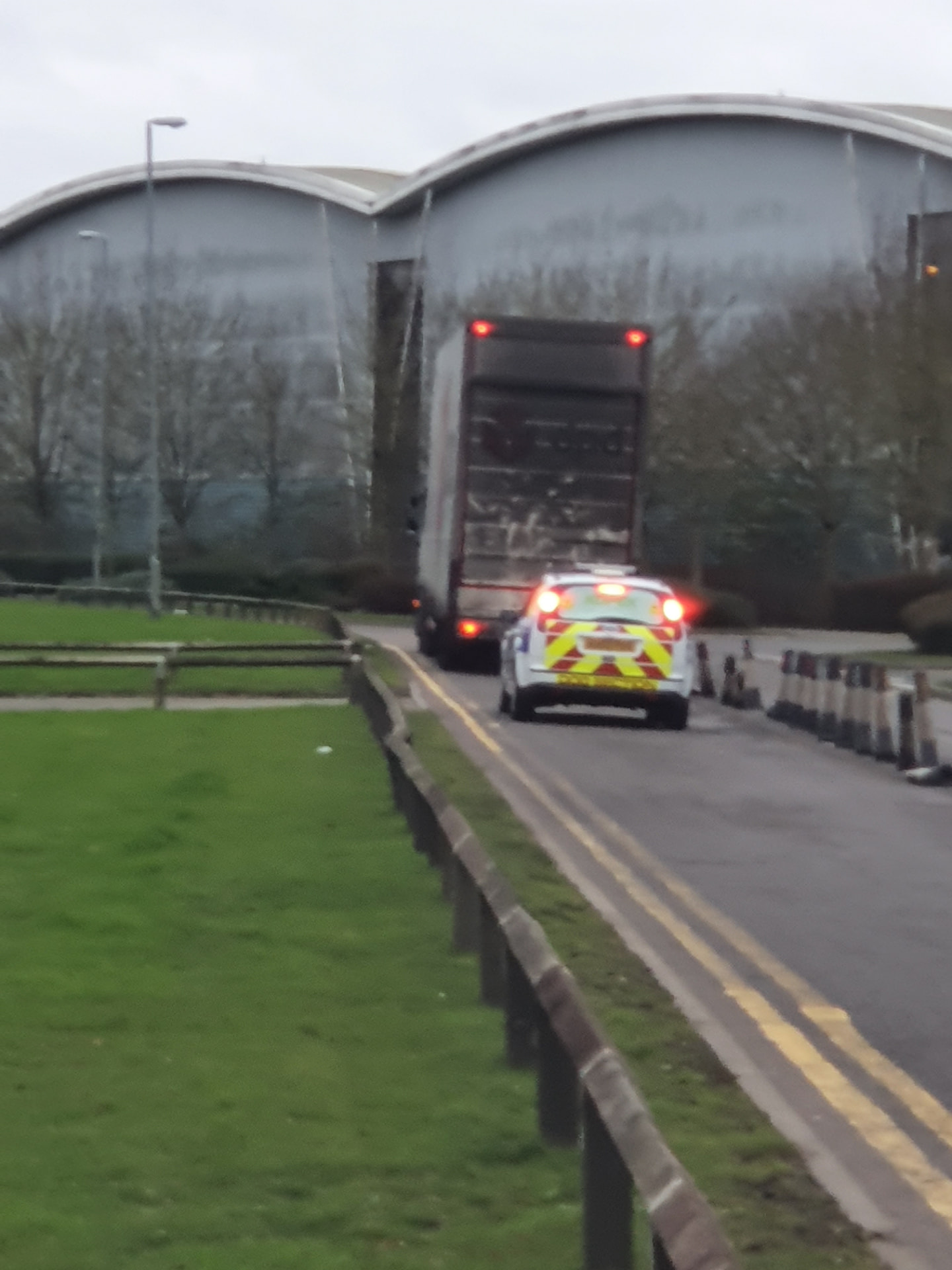 Authentic security escort vehicle accompanying a transporter into a commercial destination