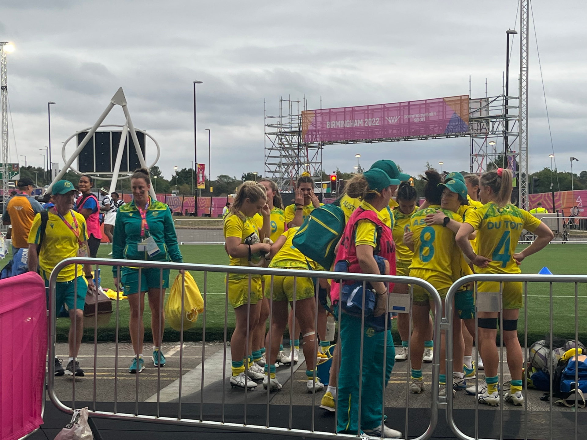 Participants and event personnel beside a controlled field-side area at Birmingham 2022