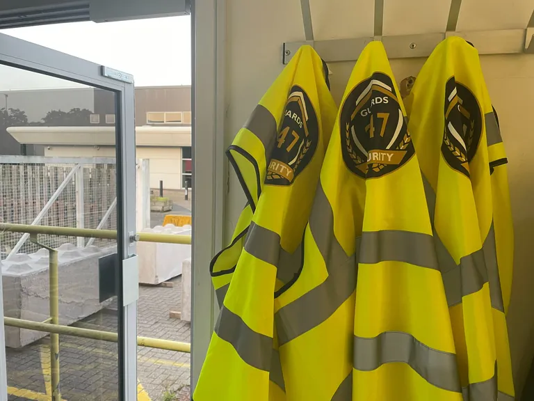 Guards 247 branded hi-vis jackets inside the site gatehouse.