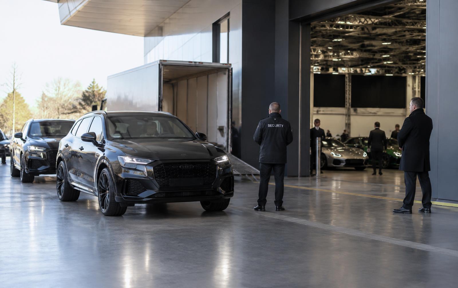 Specialist vehicles arriving at an automotive exhibition with discreet security personnel